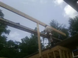 Carpenter setting a ridge beam over a new addition frame — Ice Dam Removal by Roofing Brothers in Earth City