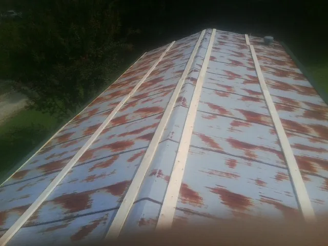 Rusted metal roof panels with new wood purlins before replacement — Storm Damage Roof Repair in Earth City by Roofing Brothers