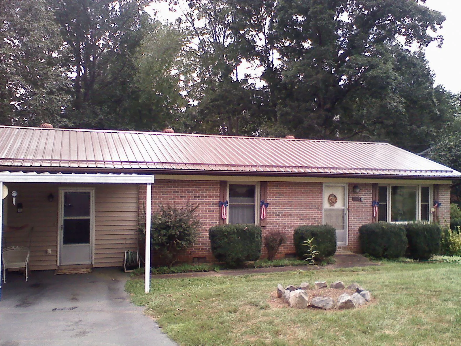 Bronze metal roof and carport on a brick ranch home — Roof Repair work by our crew in Earth City