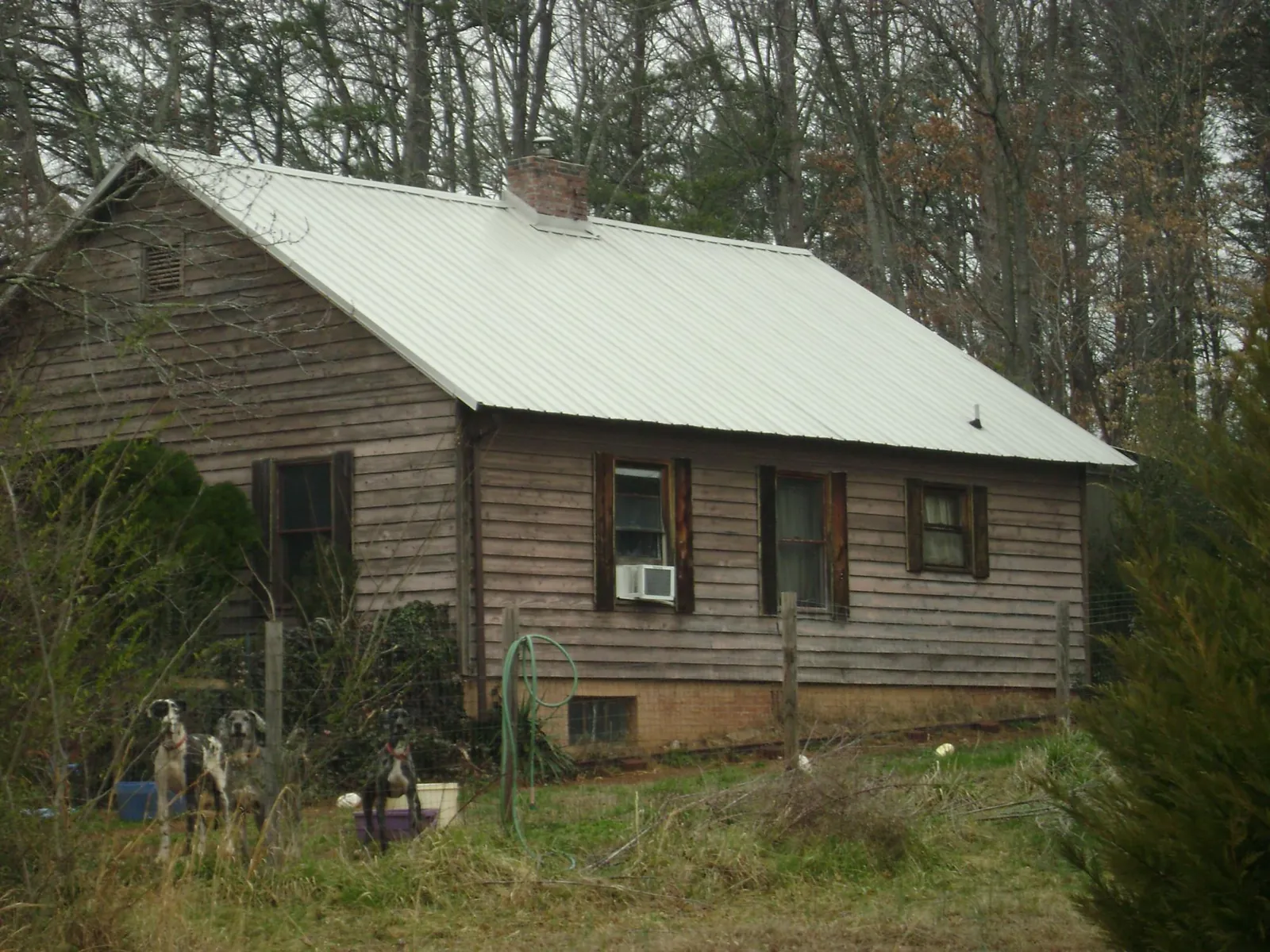 White metal roof on an old wood sided farmhouse, from a Metal Roof Installation job in Earth City